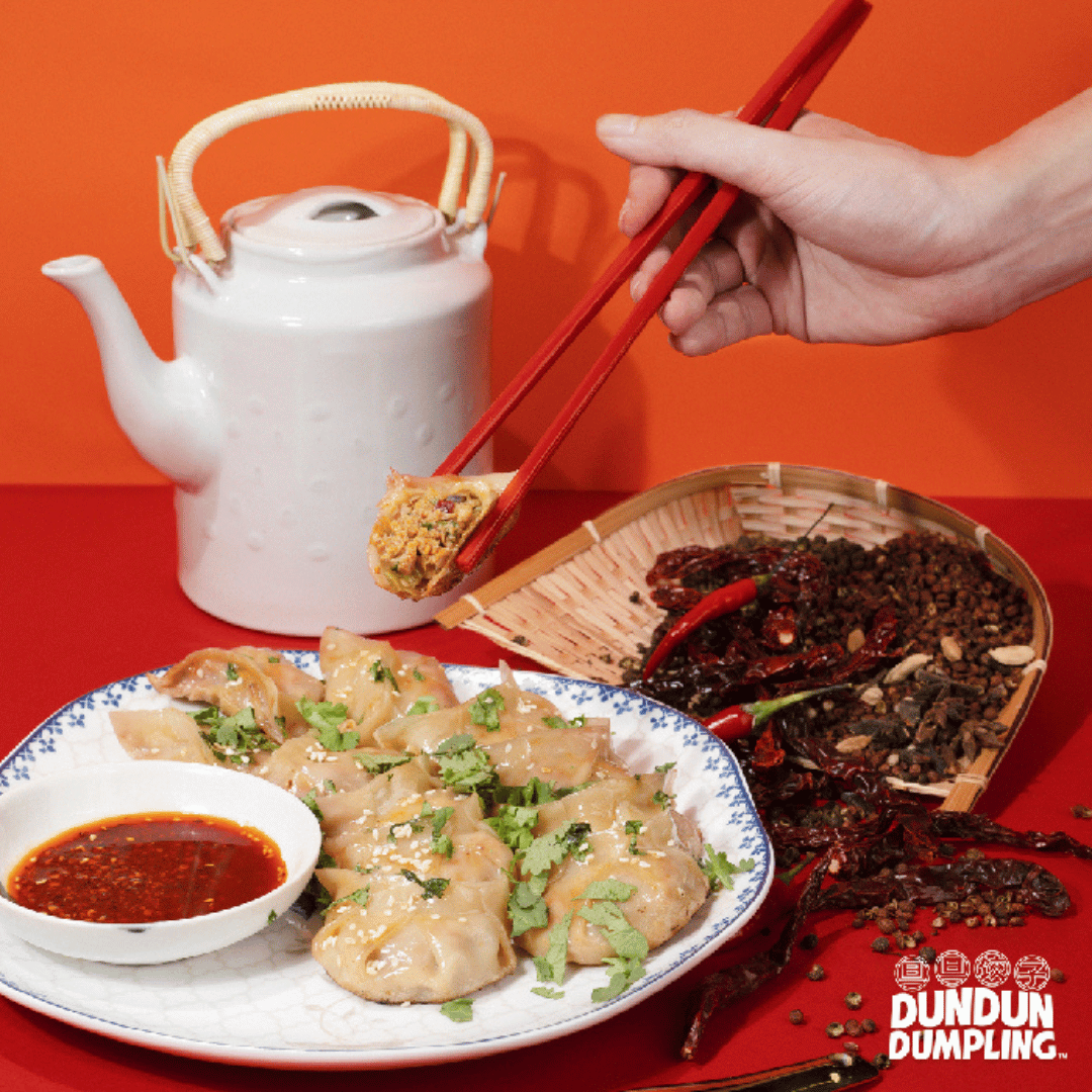 pork w mala dumpling. cooked dumpling being picked up. from side