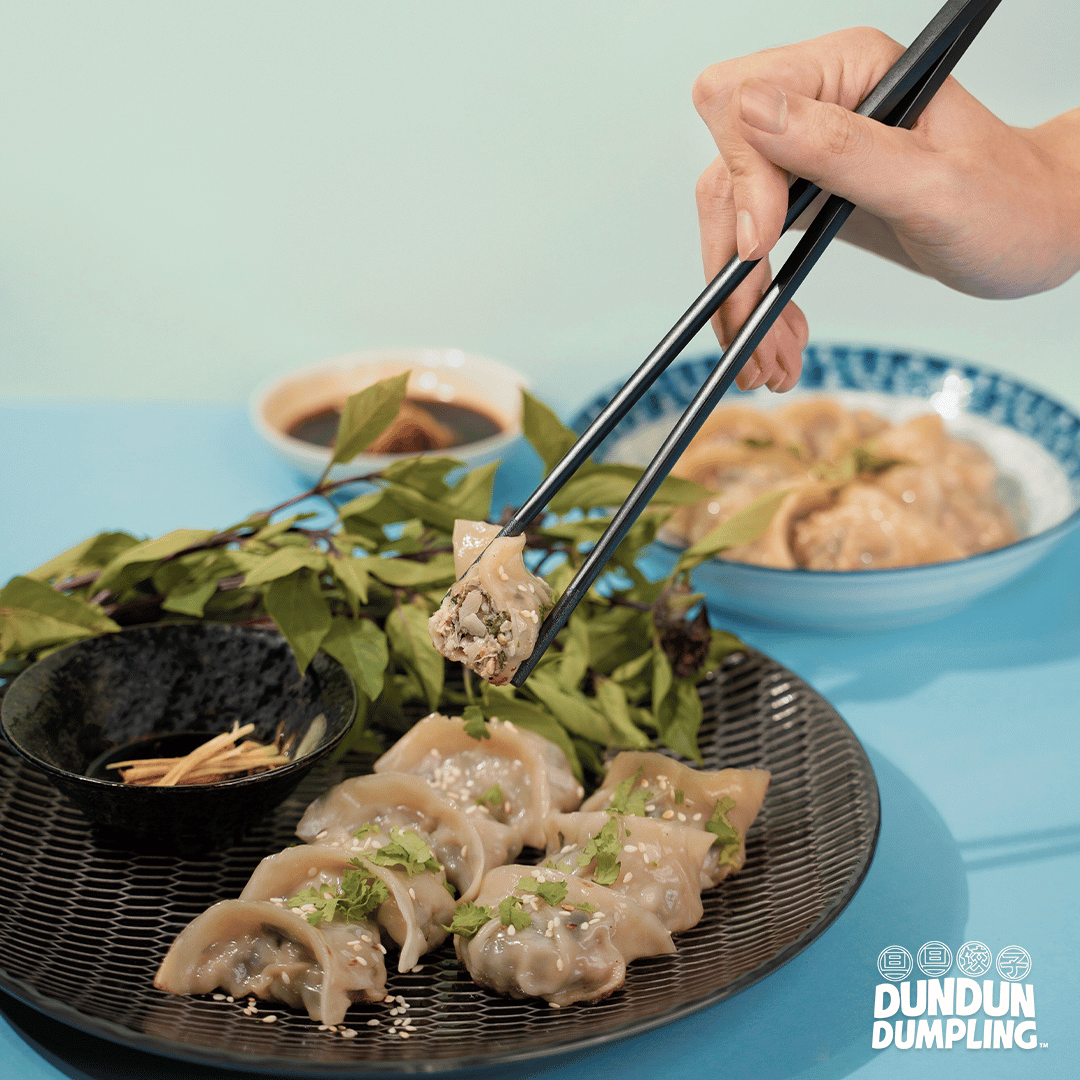 pork w basil dumpling. cooked dumpling being picked up. side